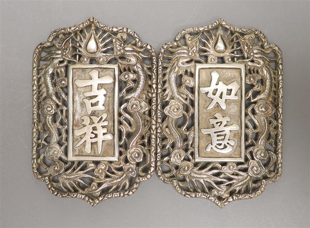 A Chinese pierced white metal nurses buckle, decorated with dragons and character marks, overall width 10.3cm.